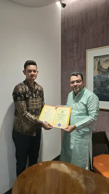 Abdul Kader Chowdhury handing over a certificate