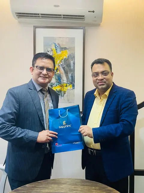 Abdul Kader Chowdhury exchanging a gift with a guest
